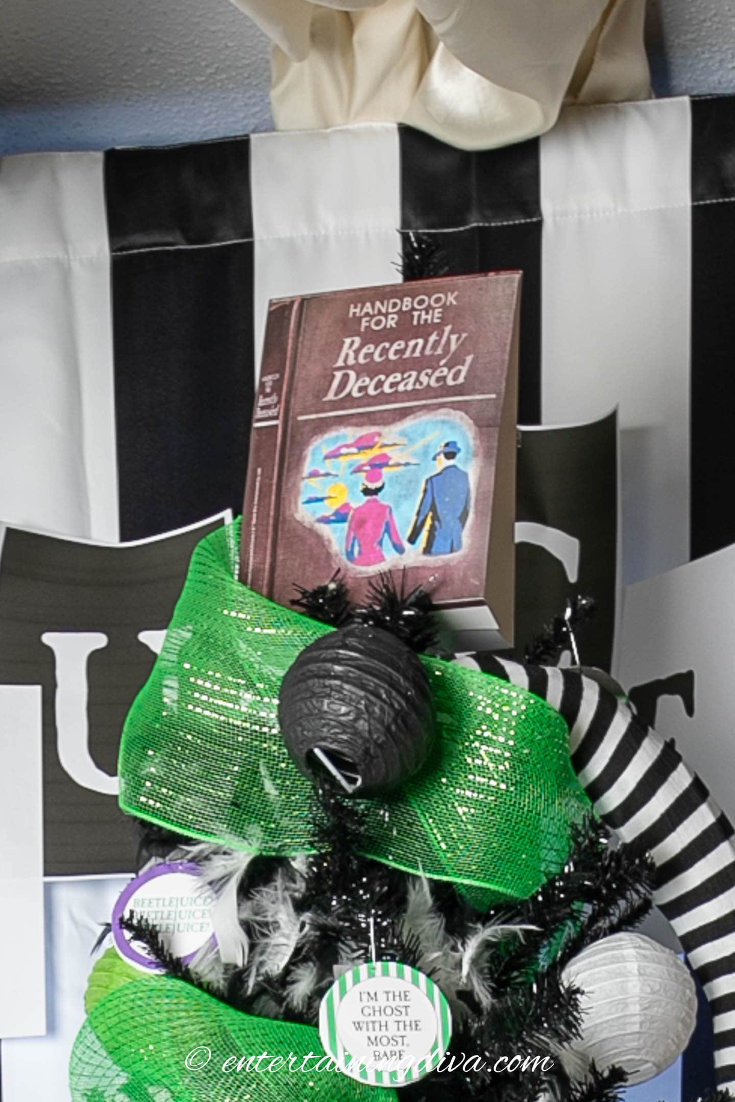 A replica of the "handbook for the recently deceased" used as a tree topper on a Beetlejuice Halloween tree