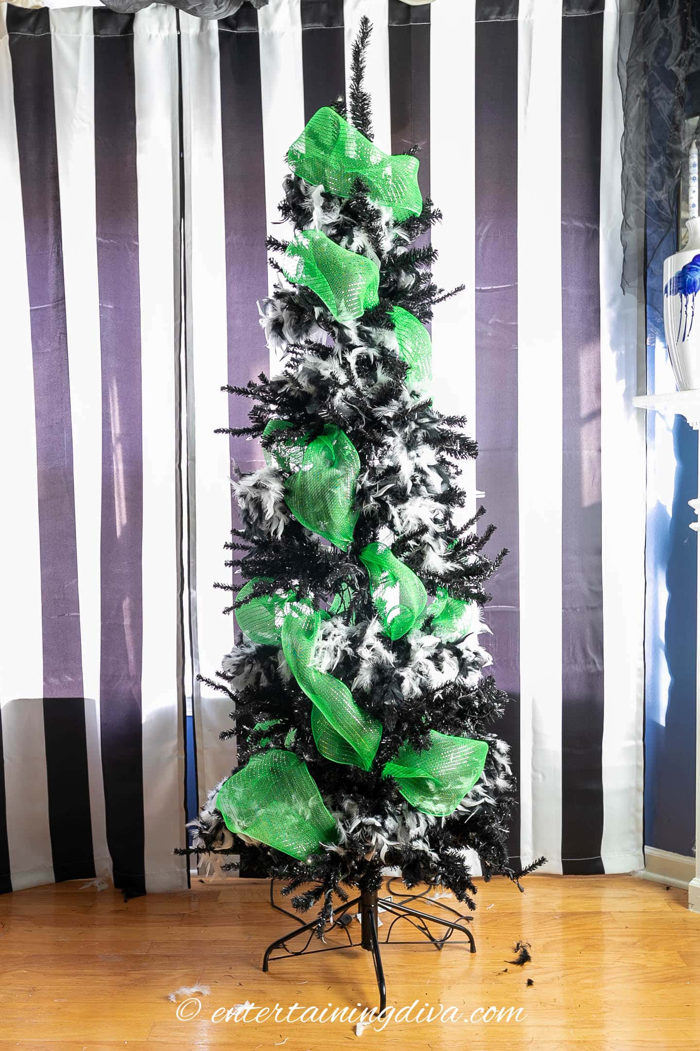 Black Halloween tree wrapped with white feather boas and lime green mesh ribbon