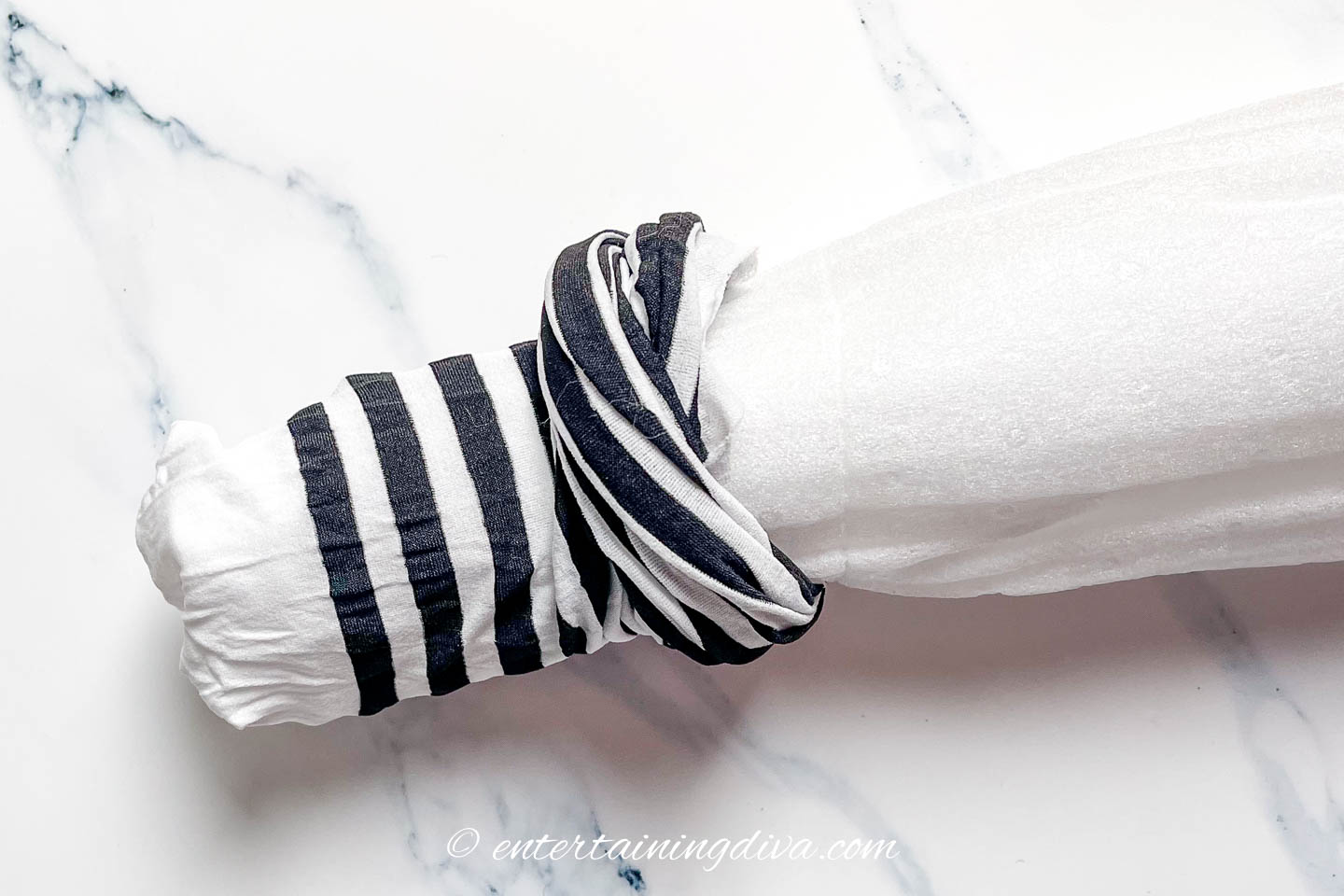Pool noodle being inserted into a black and white striped stocking 