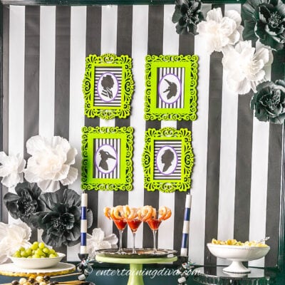 DIY Beetlejuice silhouette pictures hung above a party appetizer table