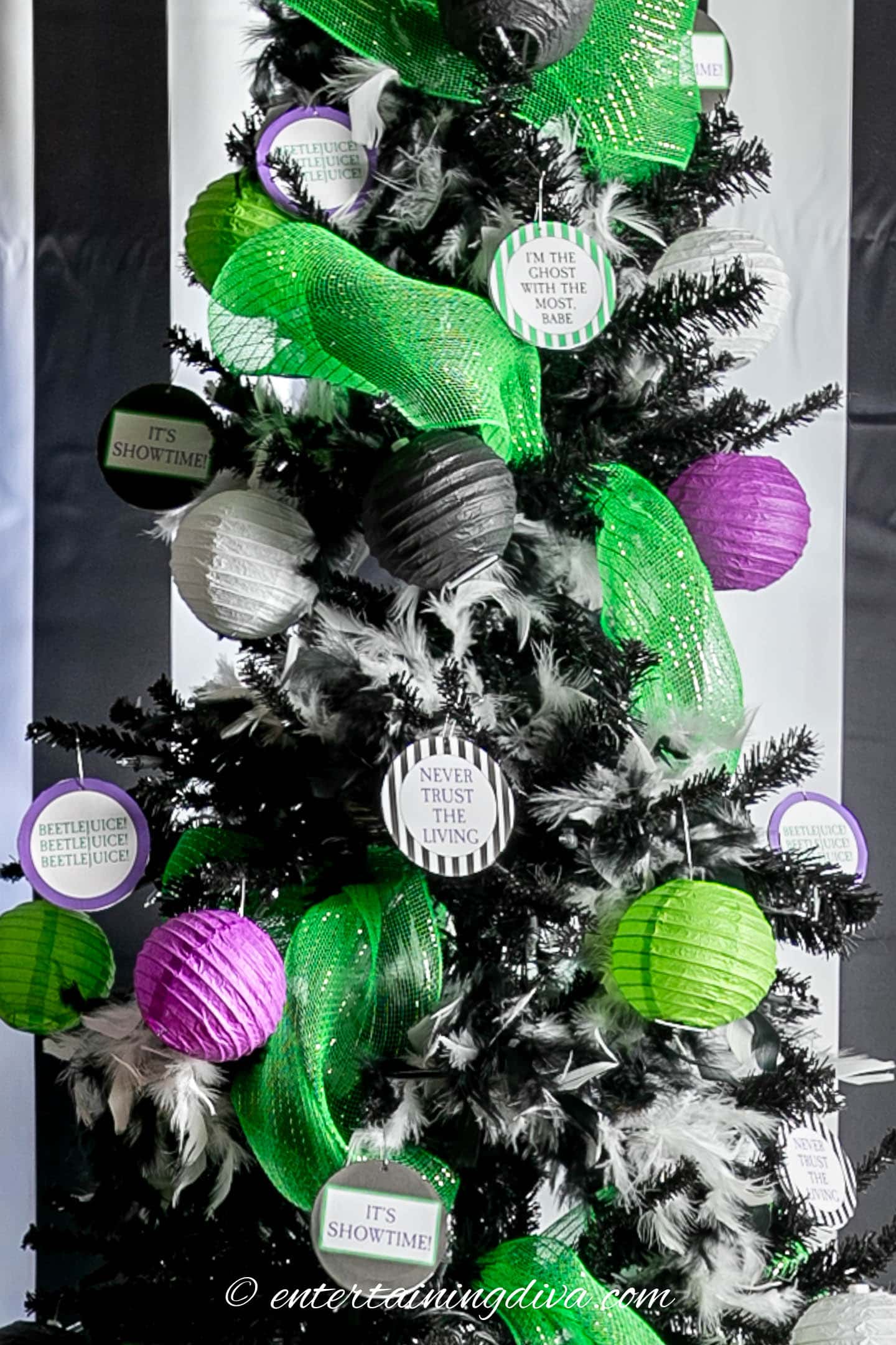 DIY Beetlejuice ornaments hung on a black Halloween tree