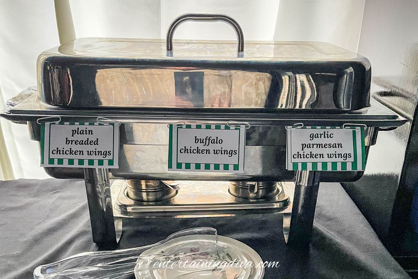 A large chafing dish with printable food labels clipped to the side of it