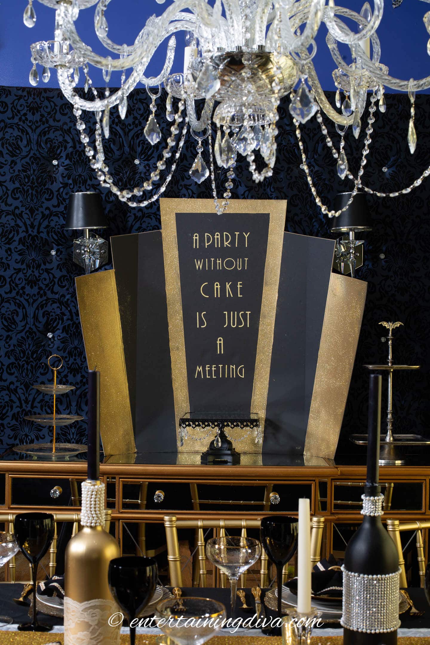 Black and gold Art Deco dessert table backdrop with the text "A Party Without Cake Is Just A Meeting" on the front