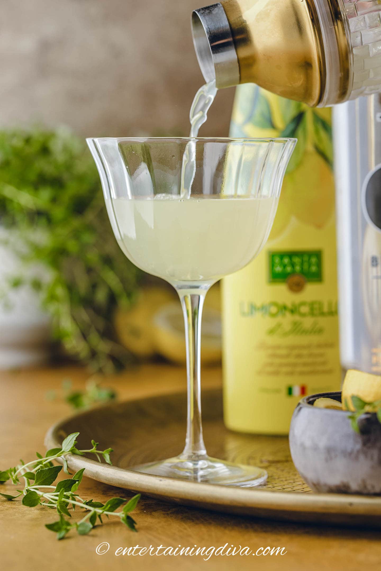 Limoncello being poured from a shaker into a glass