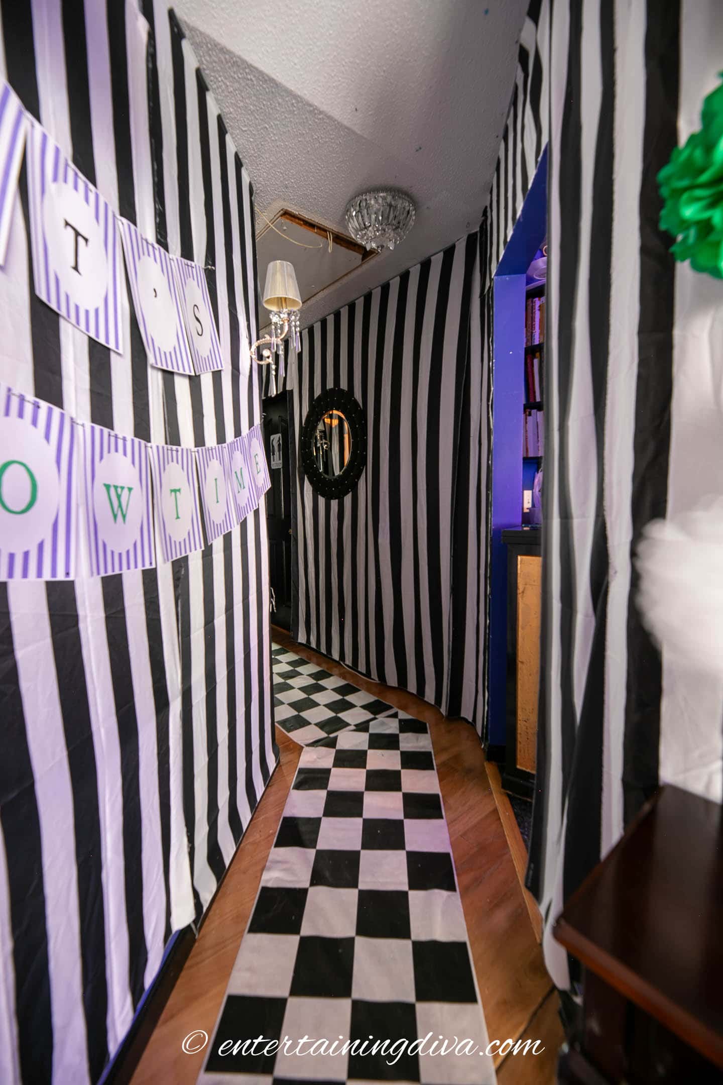 A black and white striped hallway with a black and white checkered floor at a Beetlejuice party.