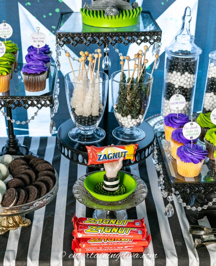 A Beetlejuice party dessert table with cupcakes, cookies and candy.