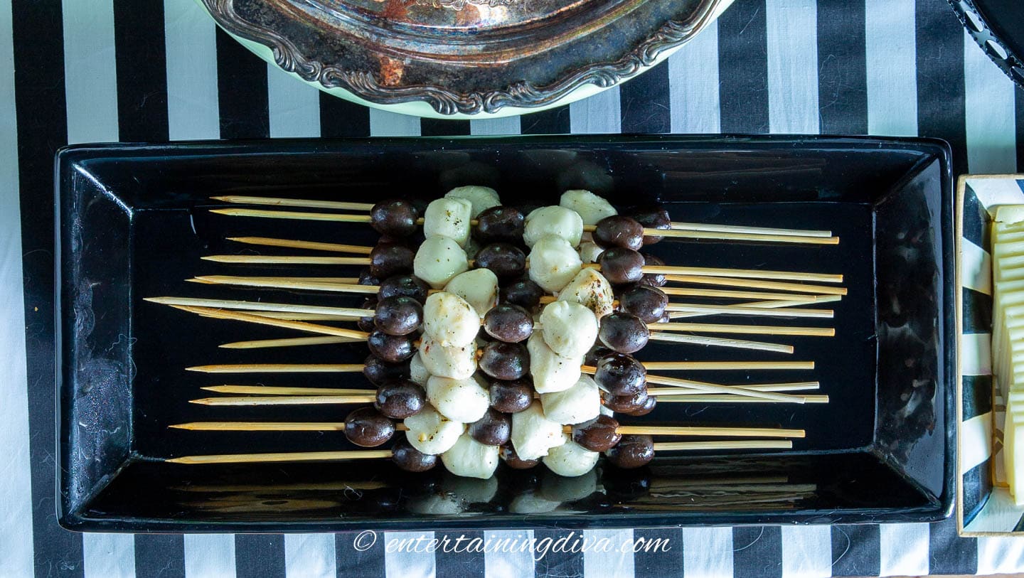 A black and white skewers on a Beetlejuice party buffet table.
