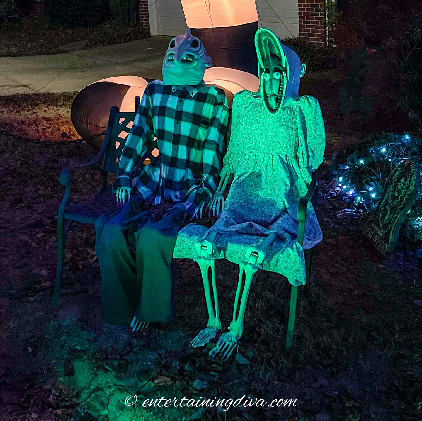 Two skeletons dressed like Adam and Barbara Maitland sitting on a bench.