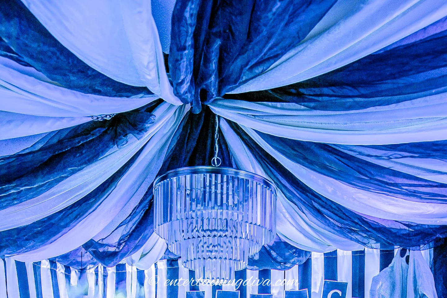 A black and white fabric tent hung from the ceiling with a chandelier.