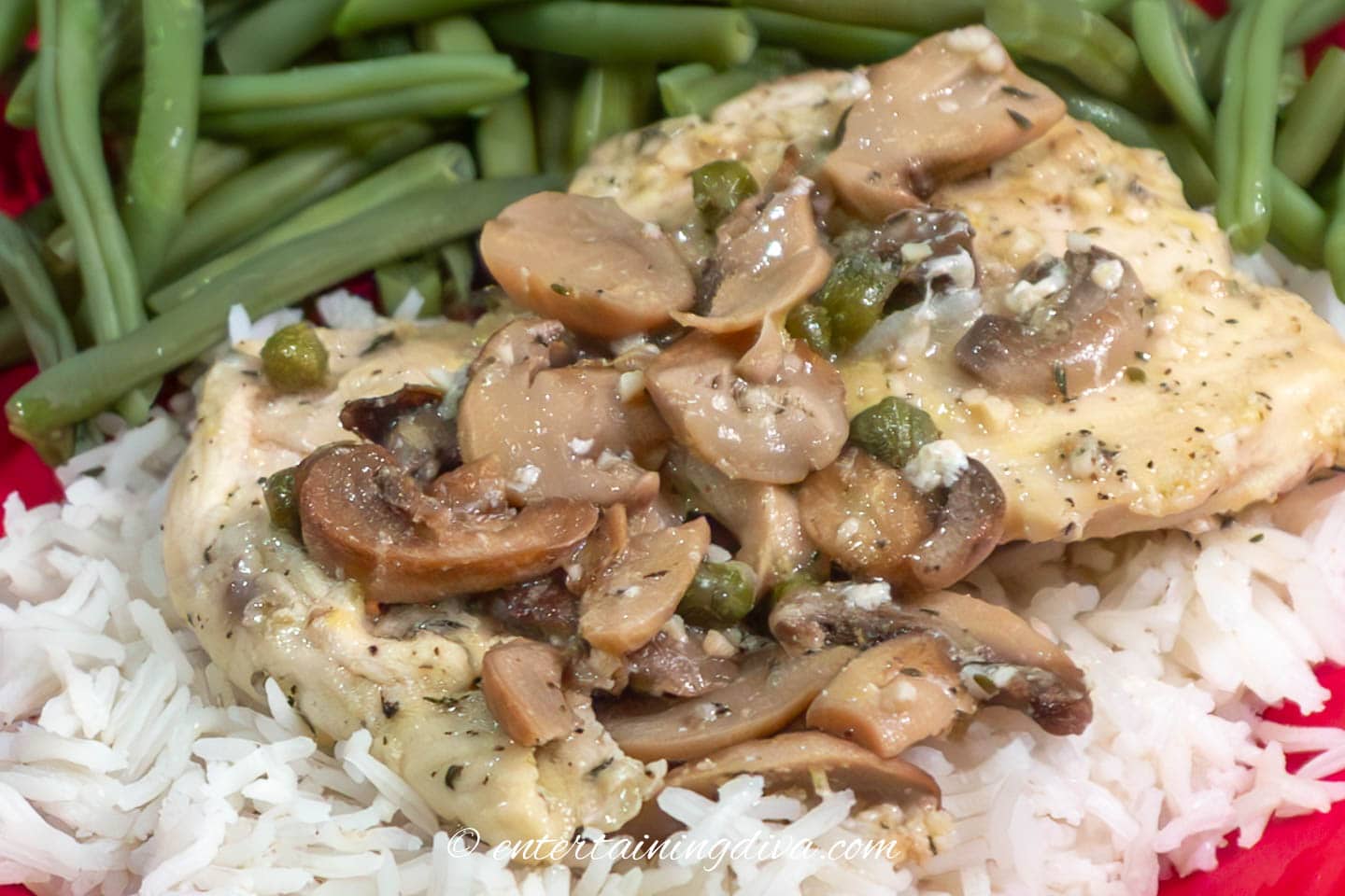 chicken piccata with mushrooms on a plate with rice