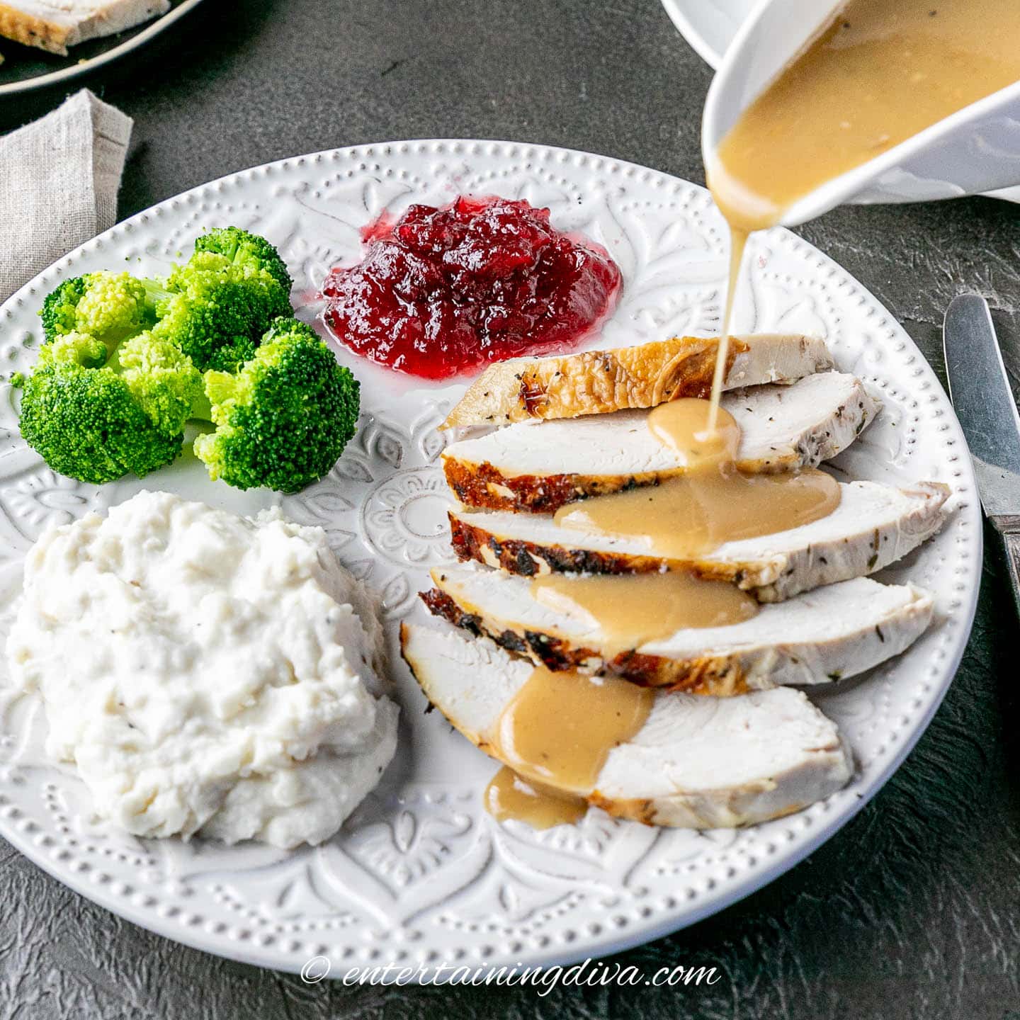 turkey gravy being poured over slices of turkey