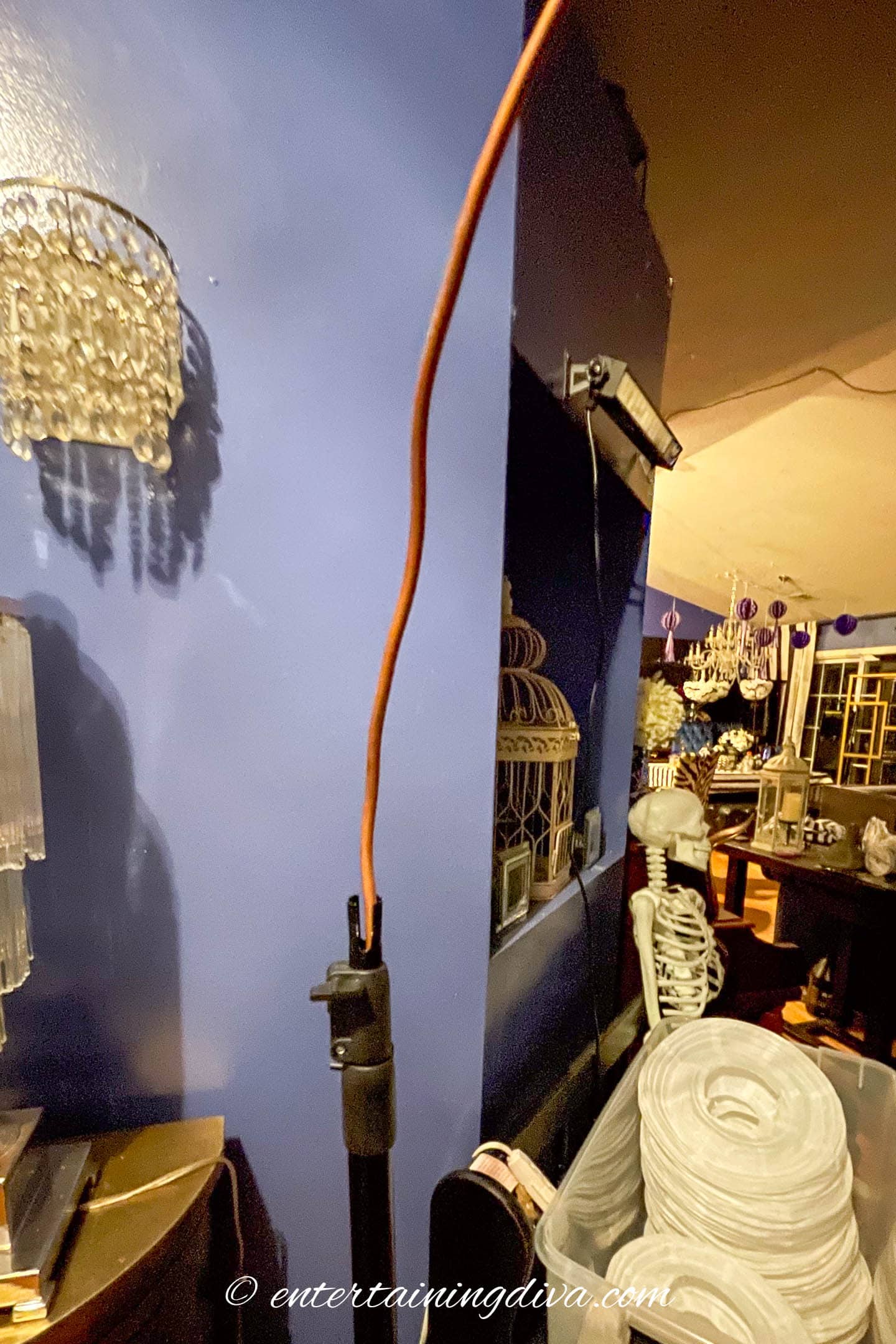 A copper pipe stuck in the top of a backdrop stand pole