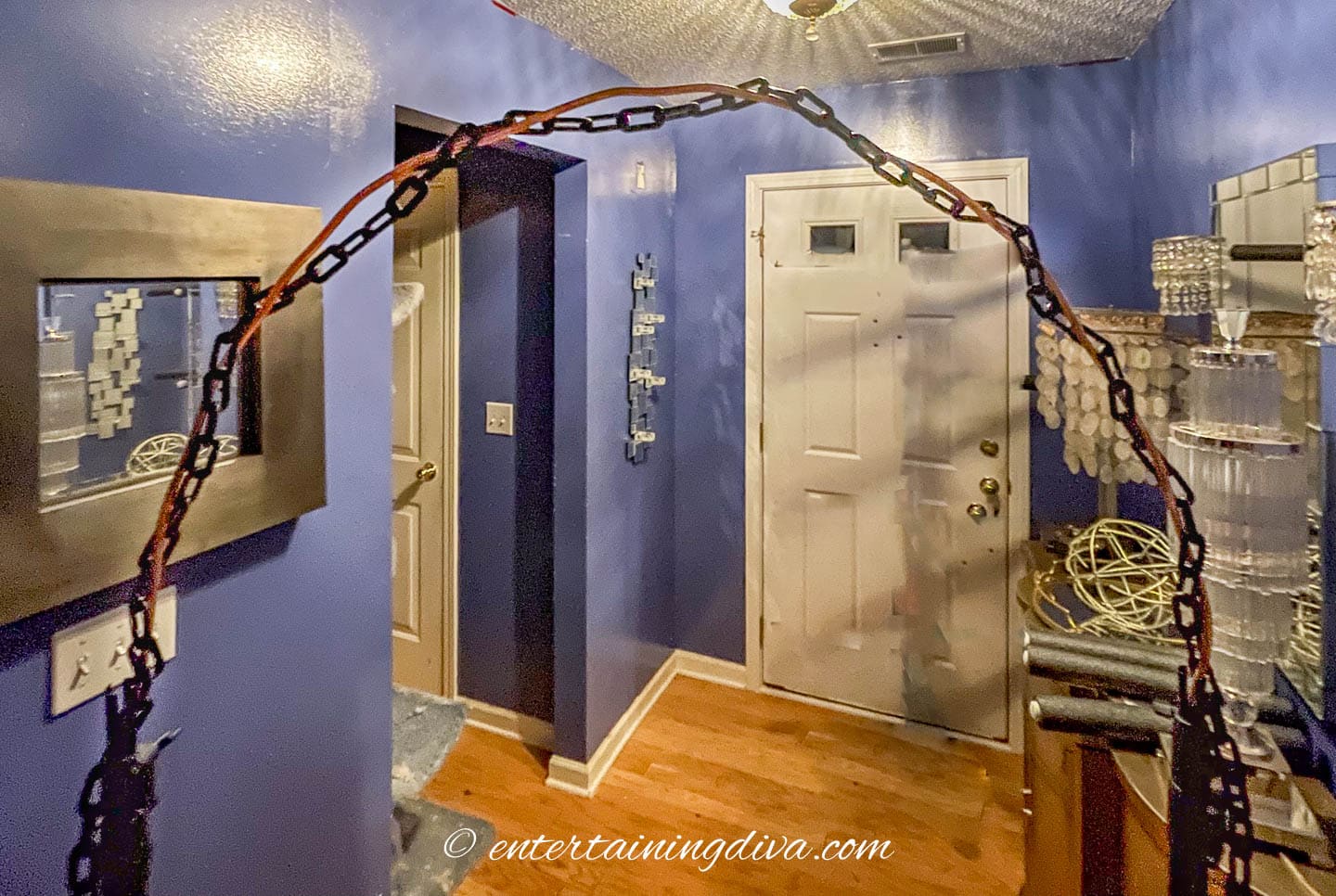 The top of a DIY paper lantern arch frame wrapped with chain
