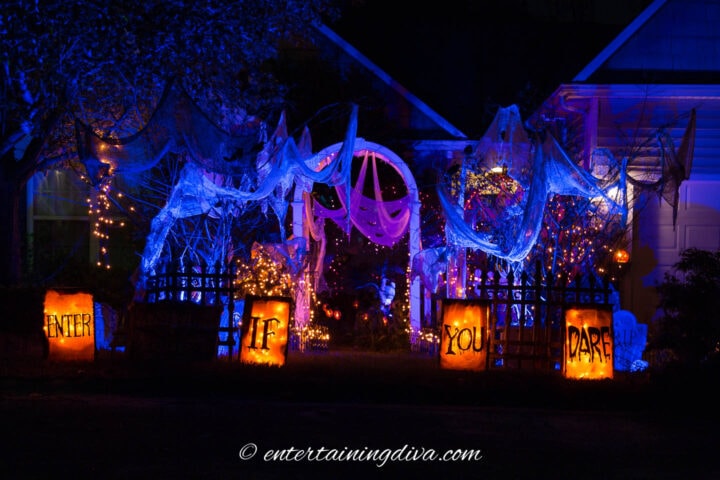 A house decorated with blue and orange Halloween outdoor lighting.