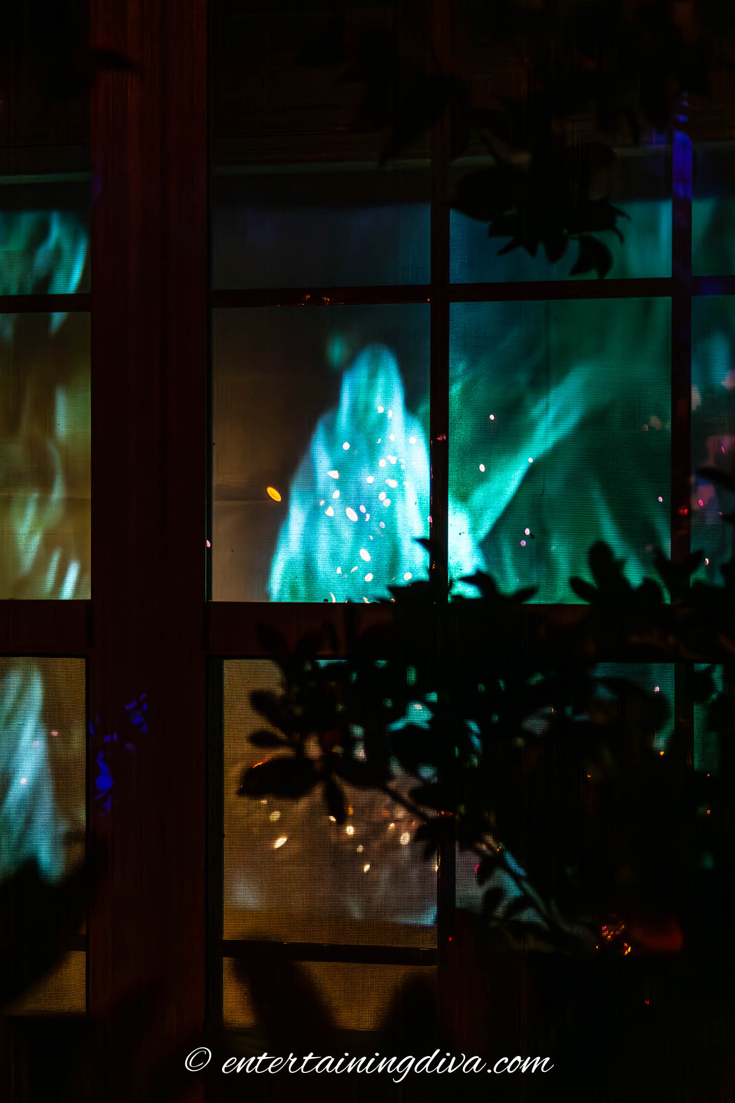 An image of a ghost projected in a Halloween window.