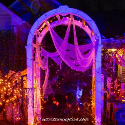 An arbor decorated with Halloween outdoor lighting and creepy cloth
