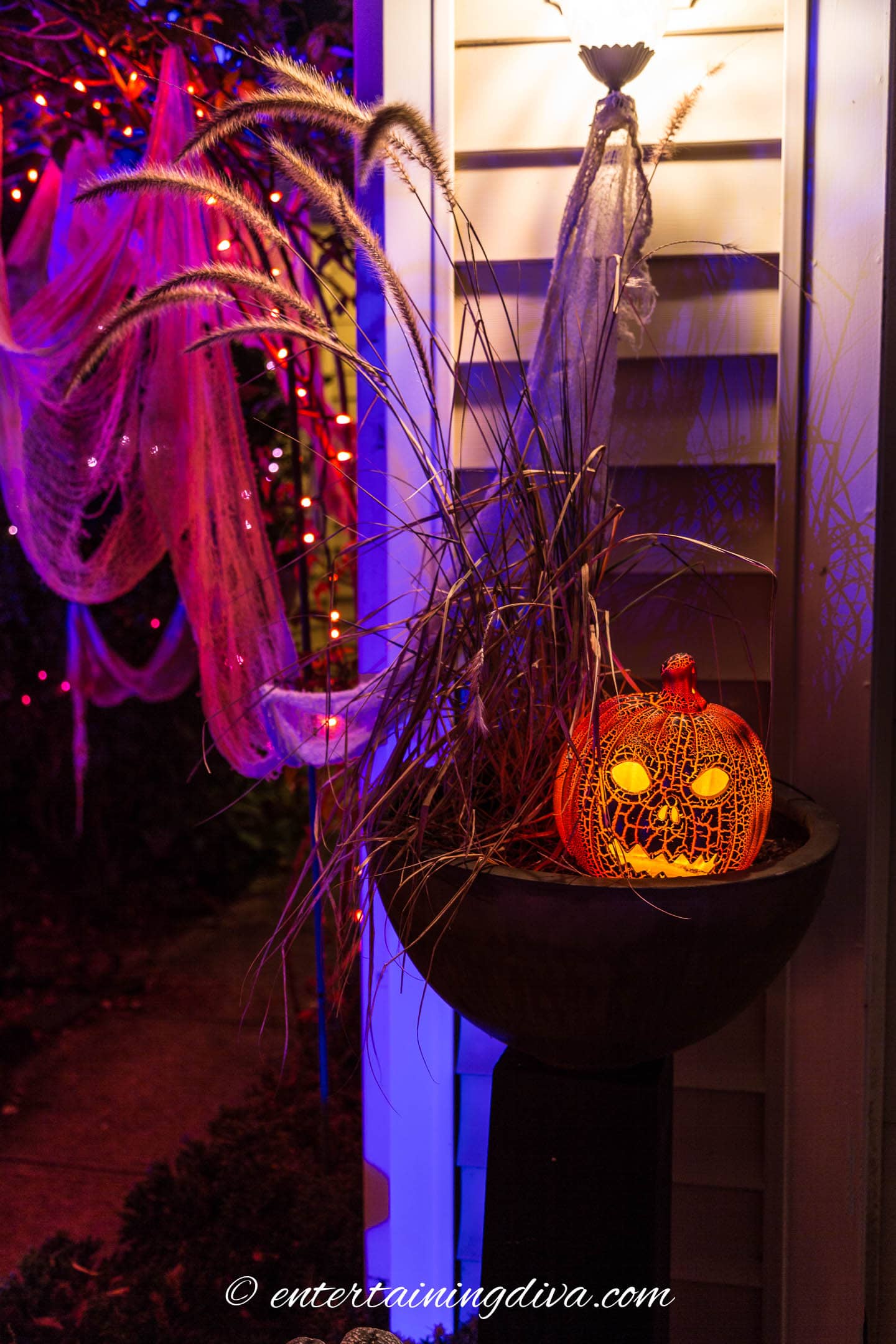 A planter with a Halloween jack o lantern for outdoor lighting.
