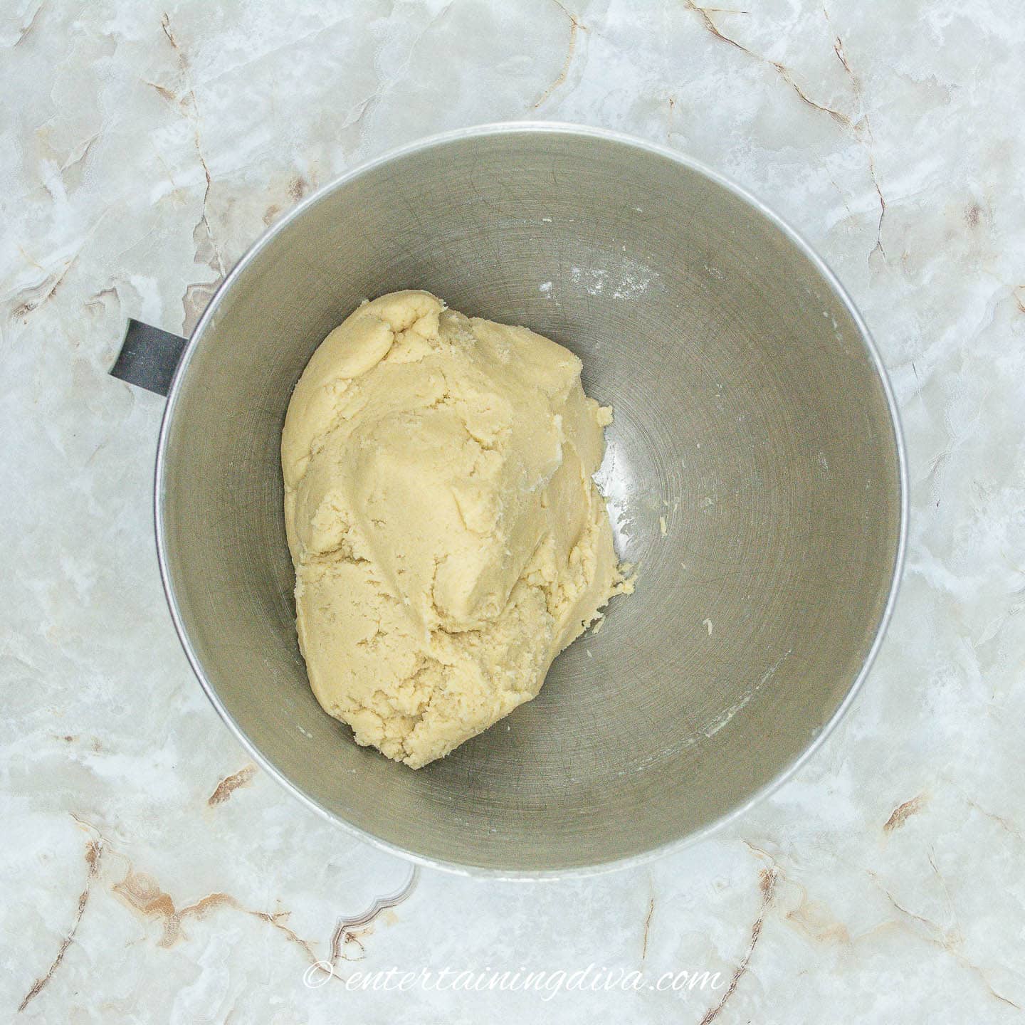 Dough for reindeer sugar cookies in a bowl on a marble countertop.