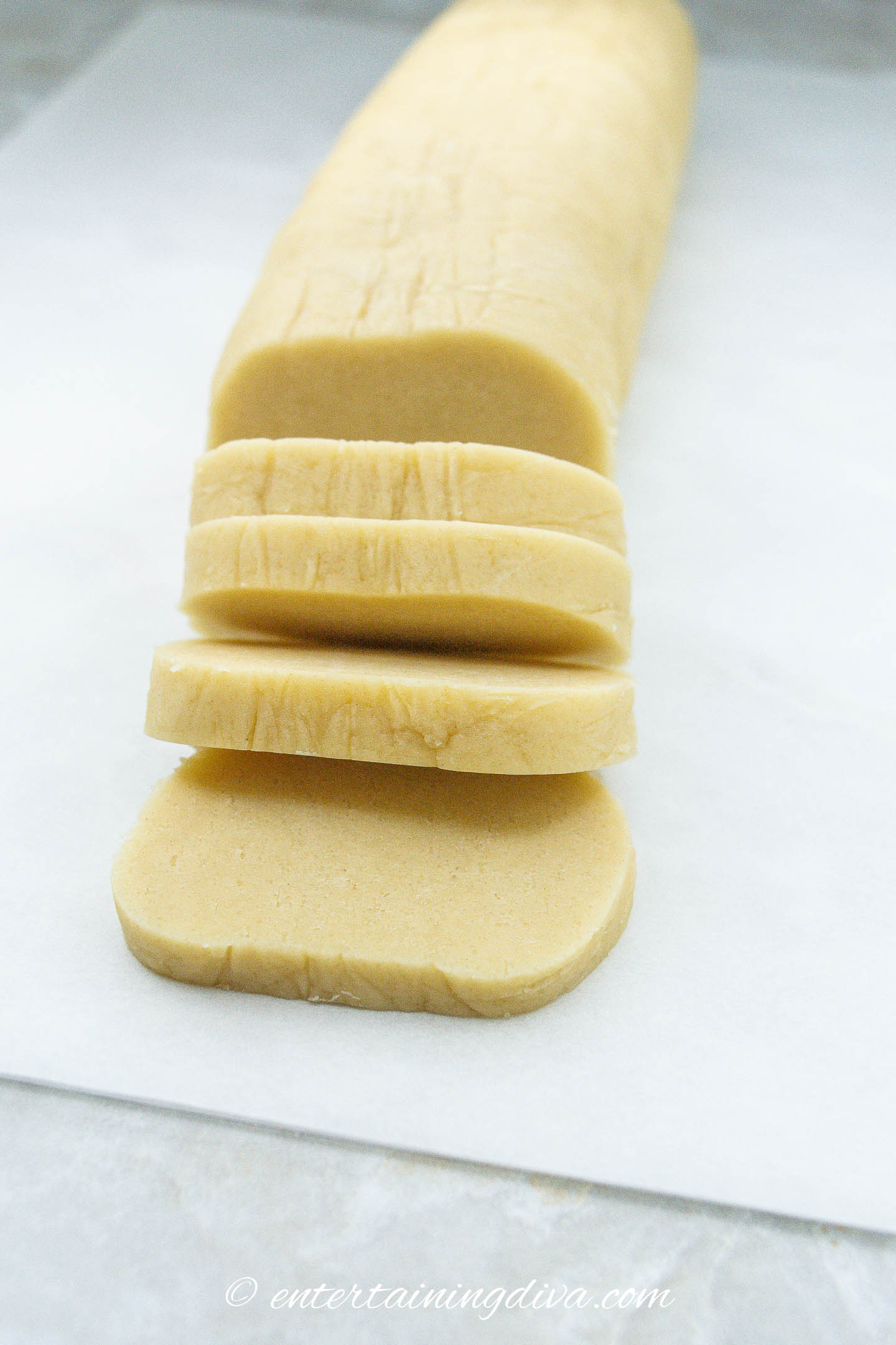 Slices of reindeer sugar cookie dough on a cutting board.