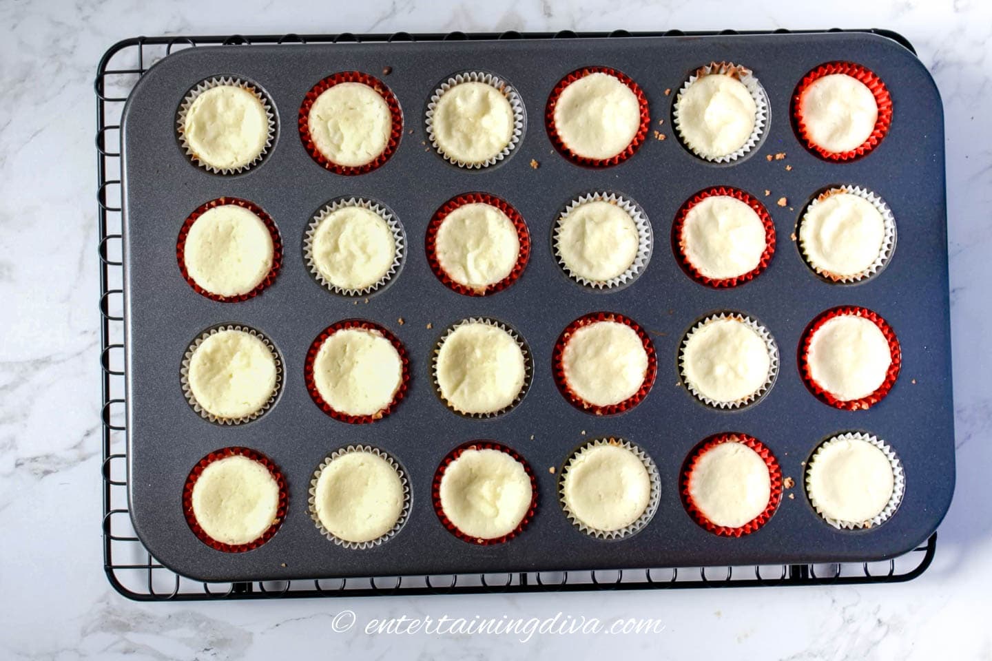 Mini cheesecakes cooling on a wire rack