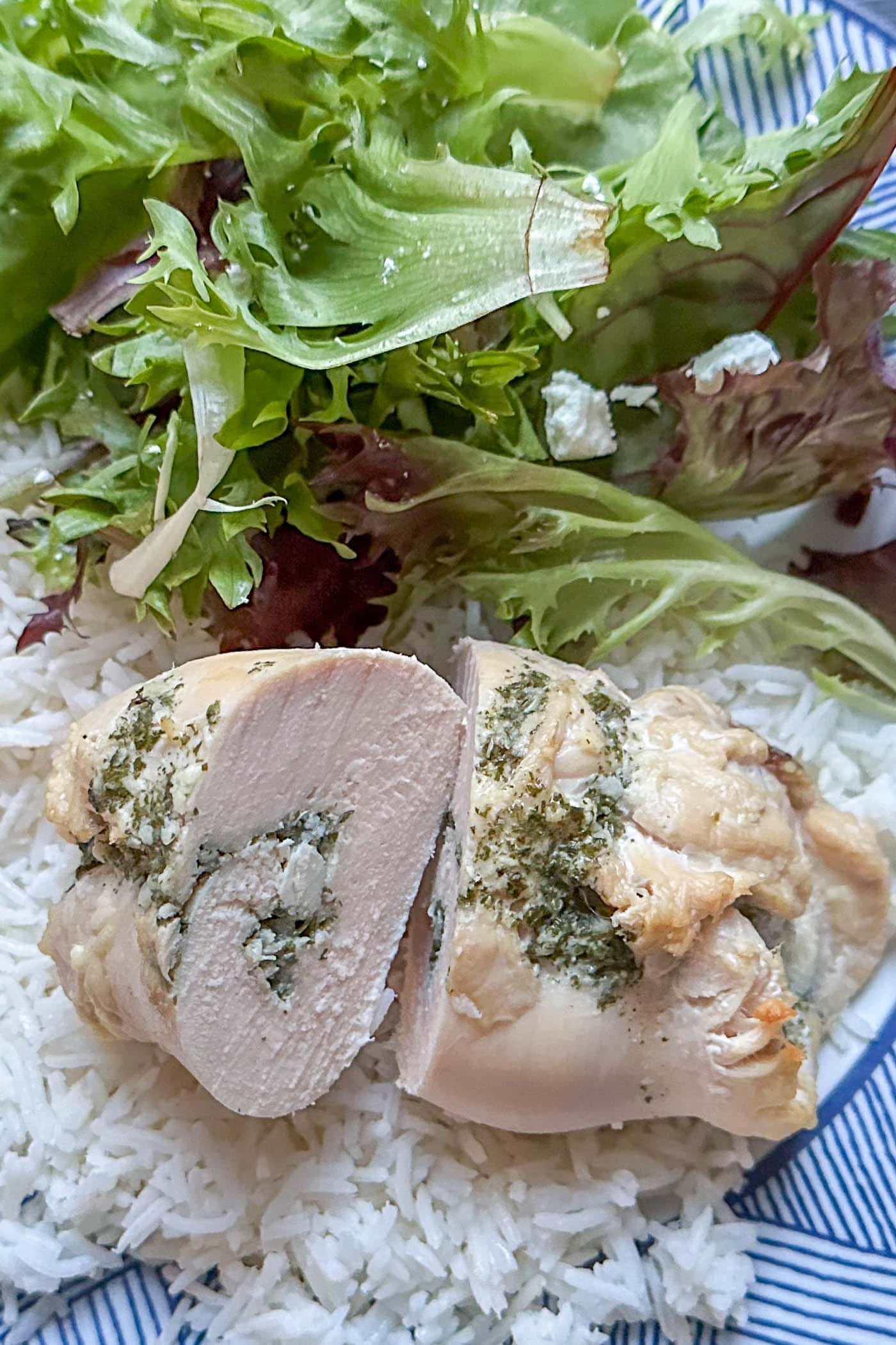 baked garlic butter chicken roll up cut in half on a plate