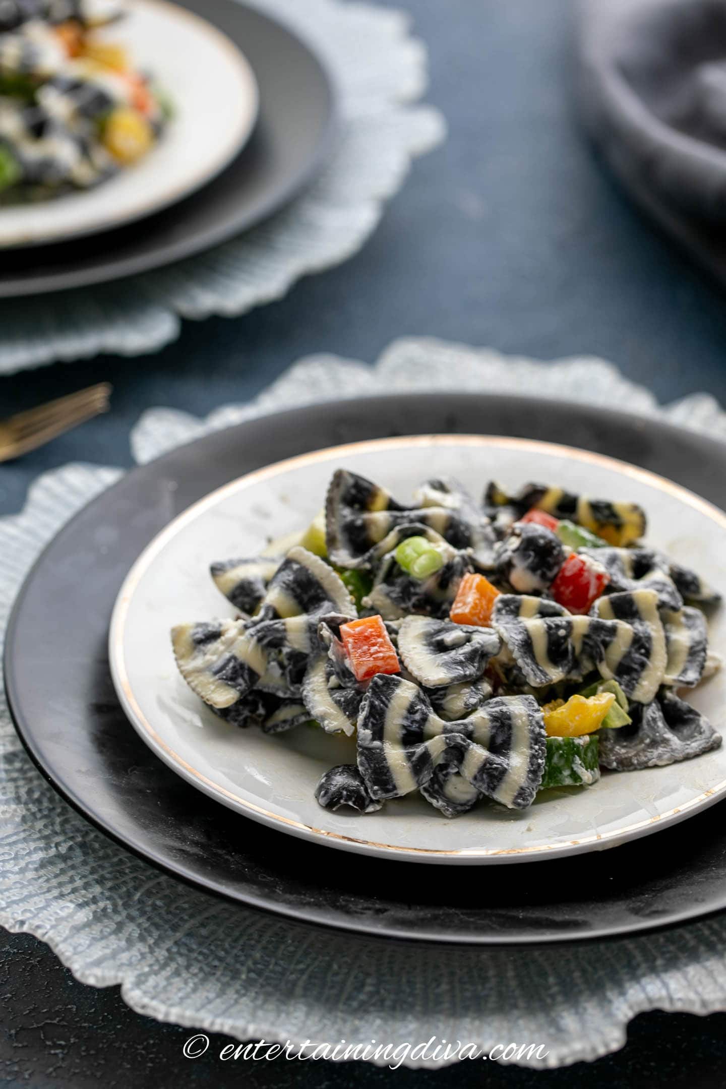 Bow tie pasta salad on a white and black place setting