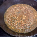 piccata sauce with capers simmering in a cast iron pan