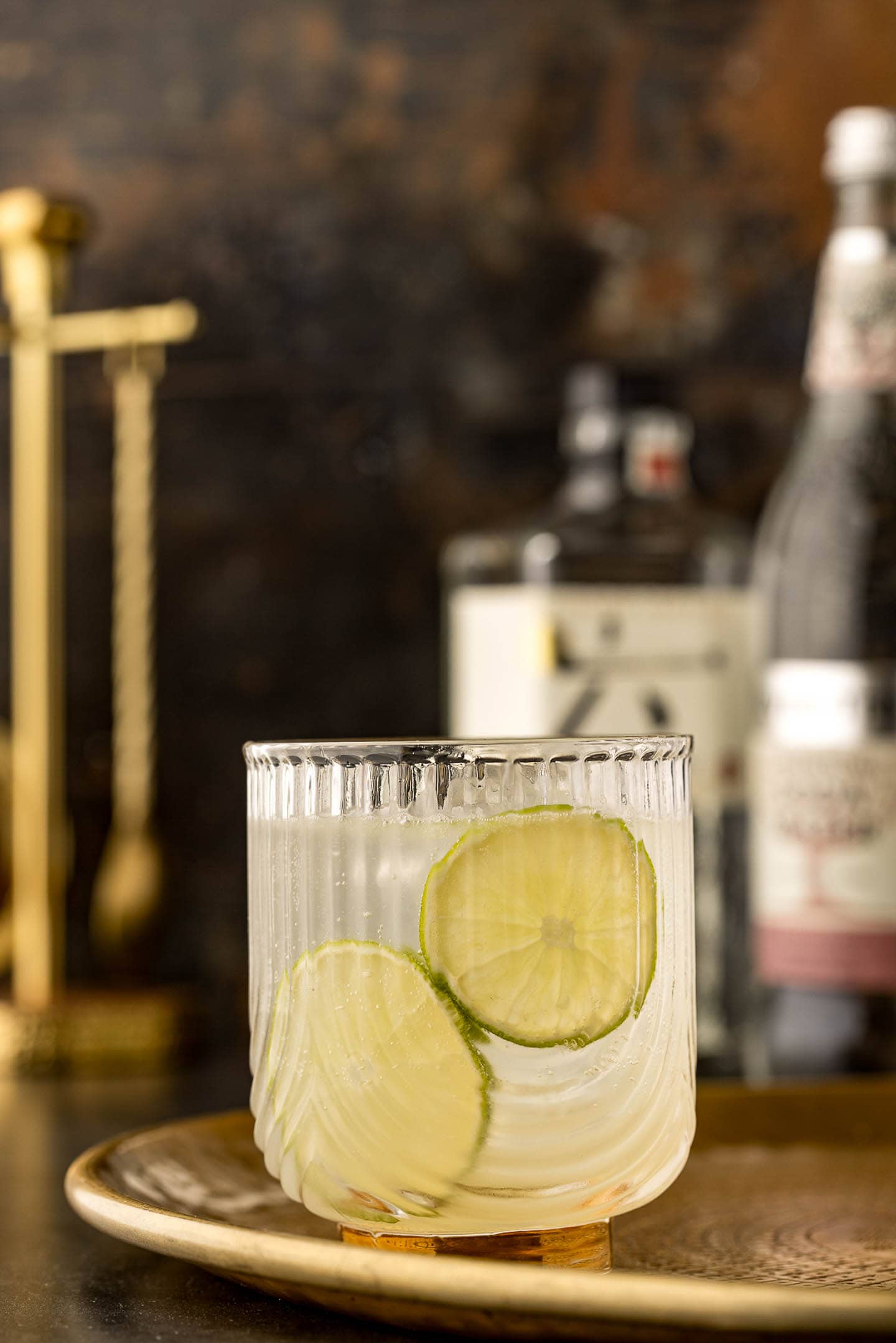 gin rickey with two lime wheels on a tray