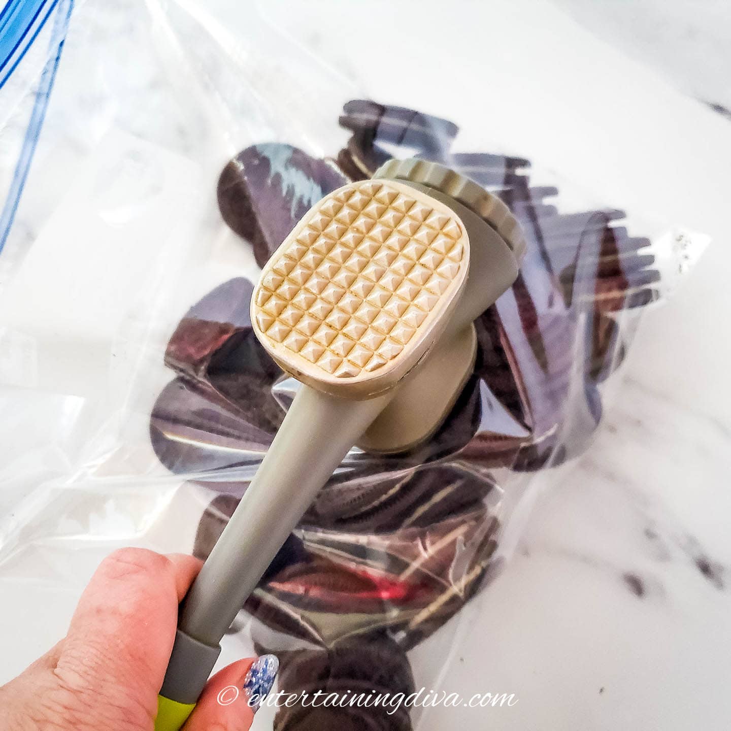 Oreo cookies being crushed with a tenderizer