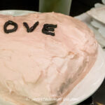pink heart shaped cake with the word LOVE in the middle