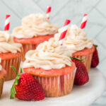 strawberry soda cupcakes with strawberry cream cheese frosting and a red and white striped straw