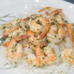 Thai red curry shrimp on a plate with rice