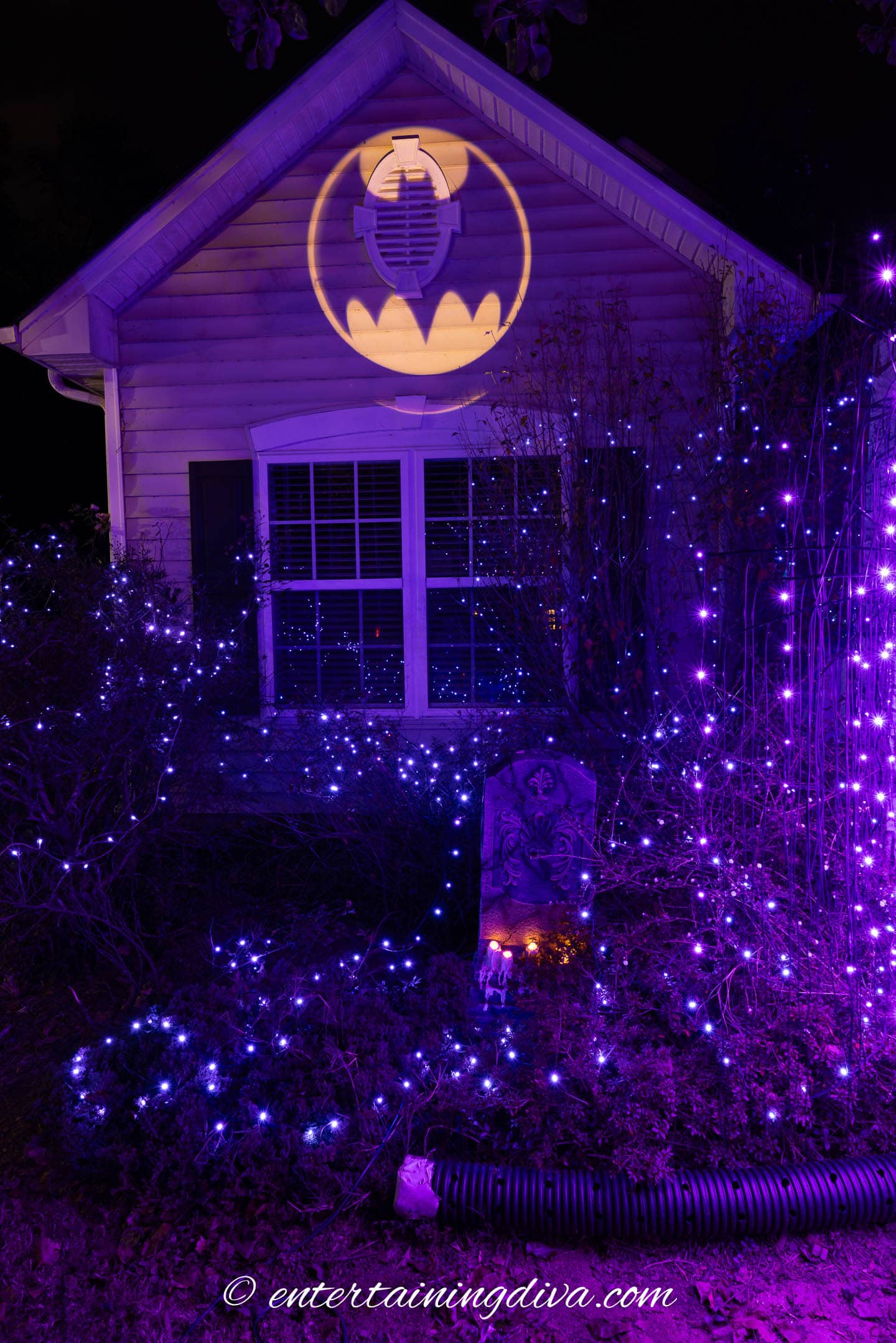 The bat signal projected onto the side of the house