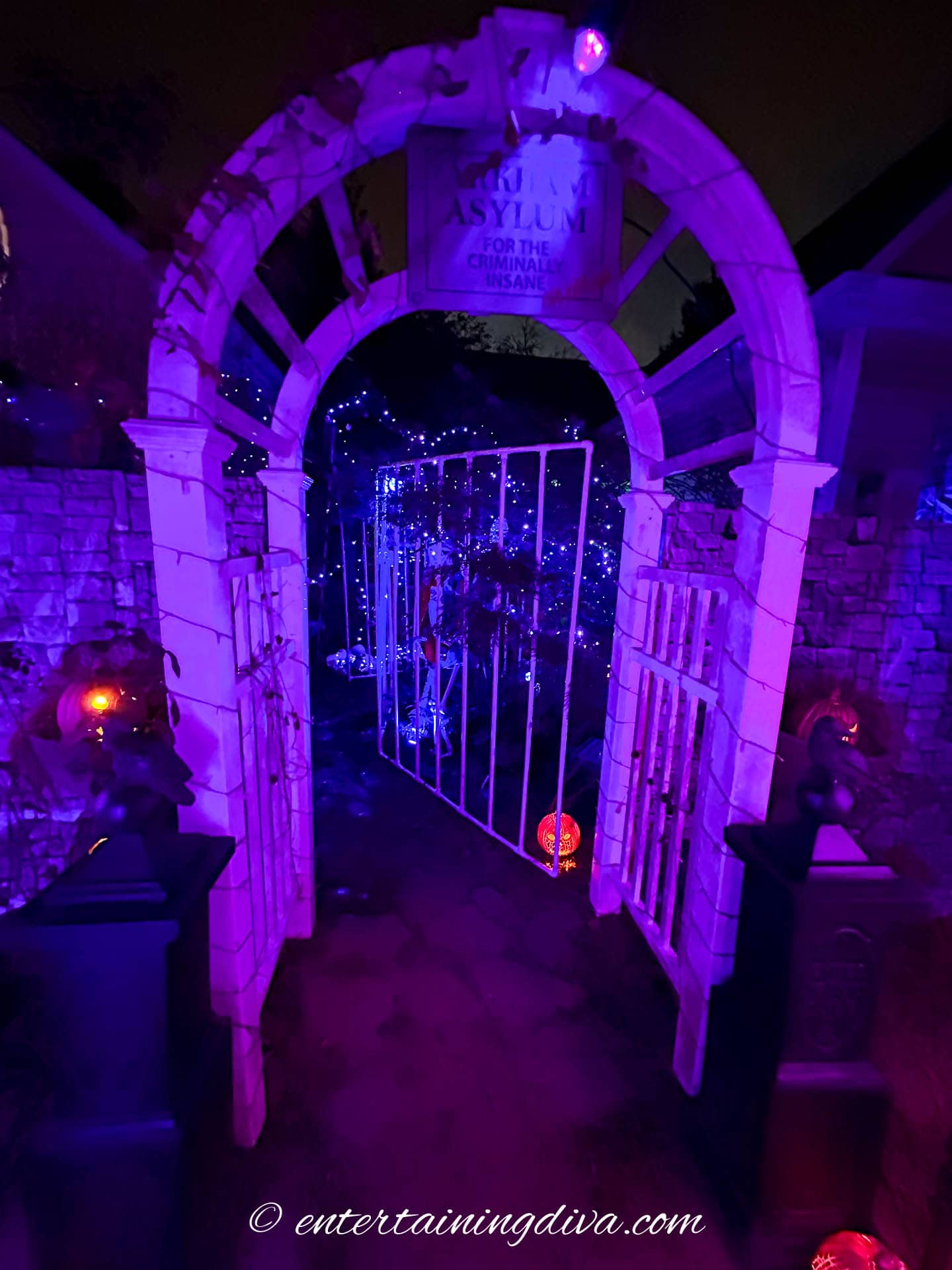 The Arkham Asylum sign at the top of the arbor at night