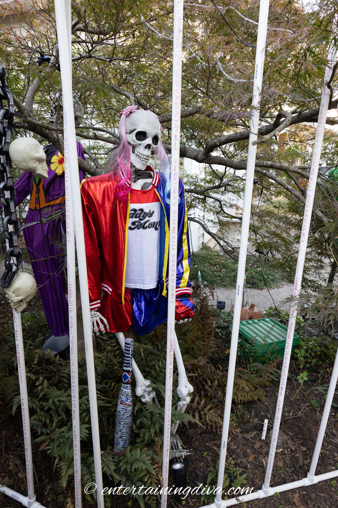 A skeleton dressed as Harley Quinn inside an Arkham Asylum cell outdoor Halloween decor
