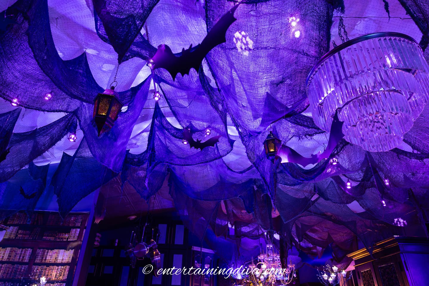 The ceiling at a batman party with creepy cloth, bats, and lanterns hung from it