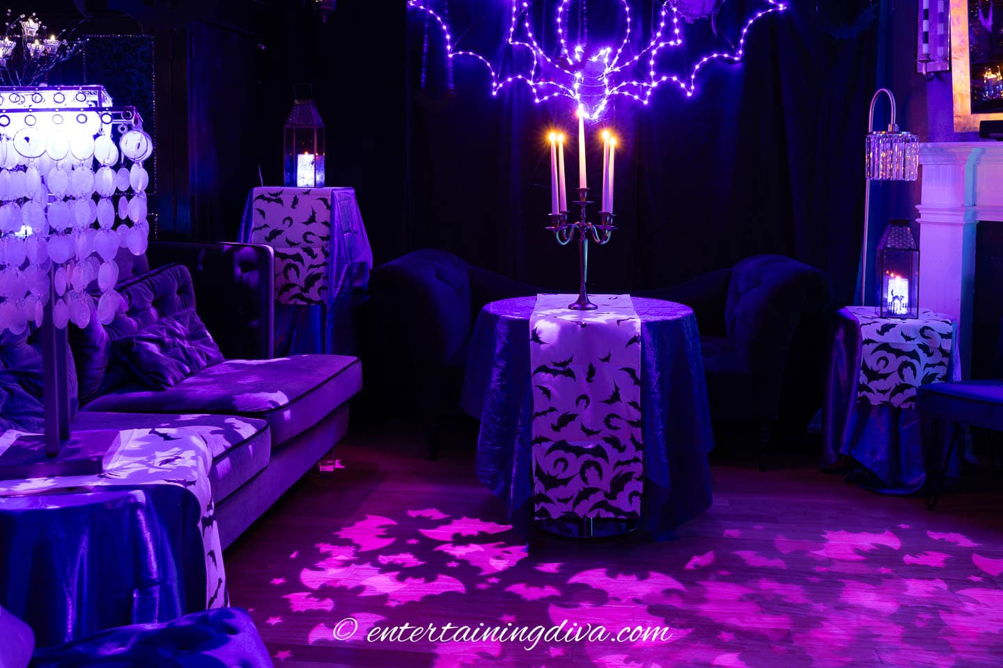 Tables with bat runners and candles at a batman Halloween party