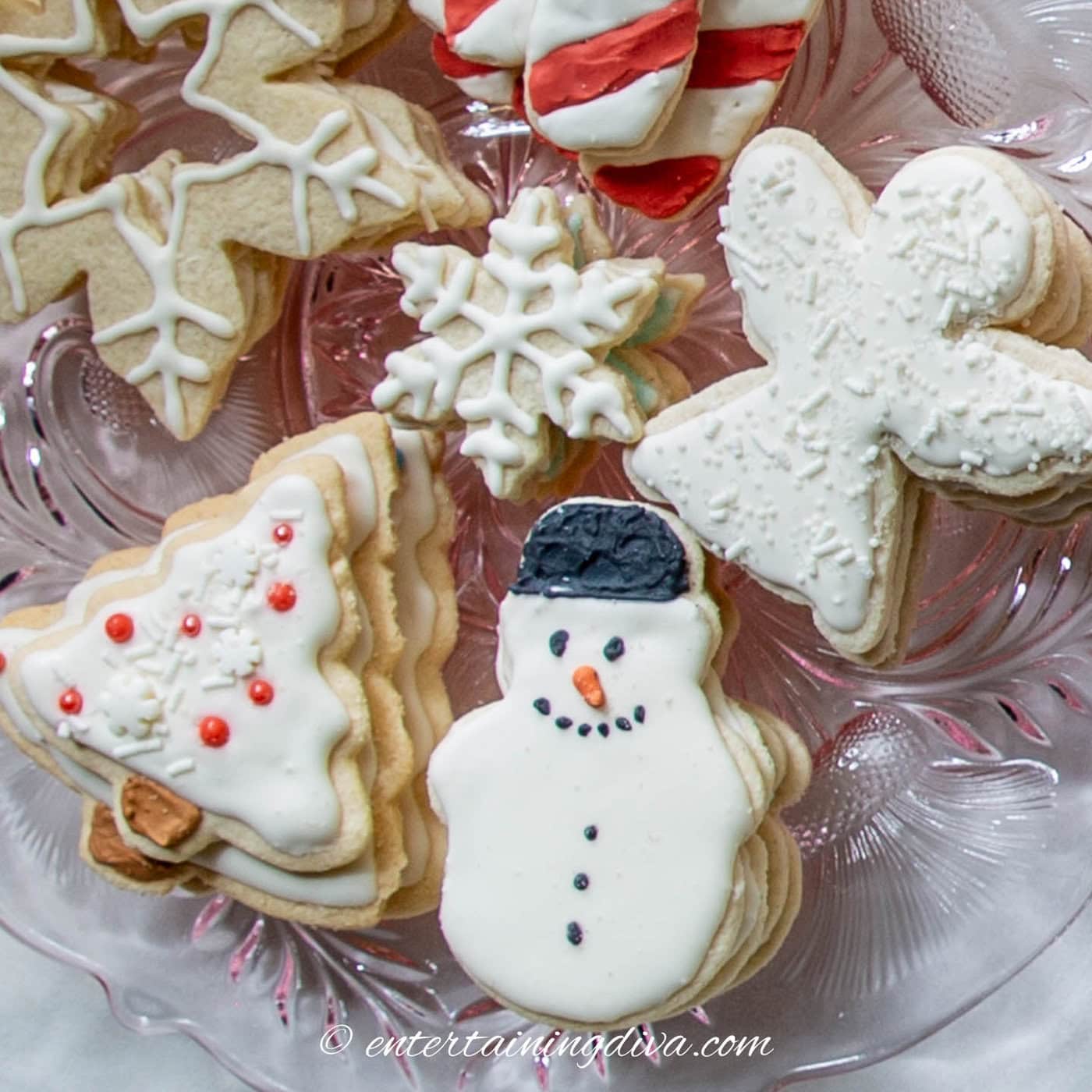 Sugar cookies decorated with white royal icing on a plate