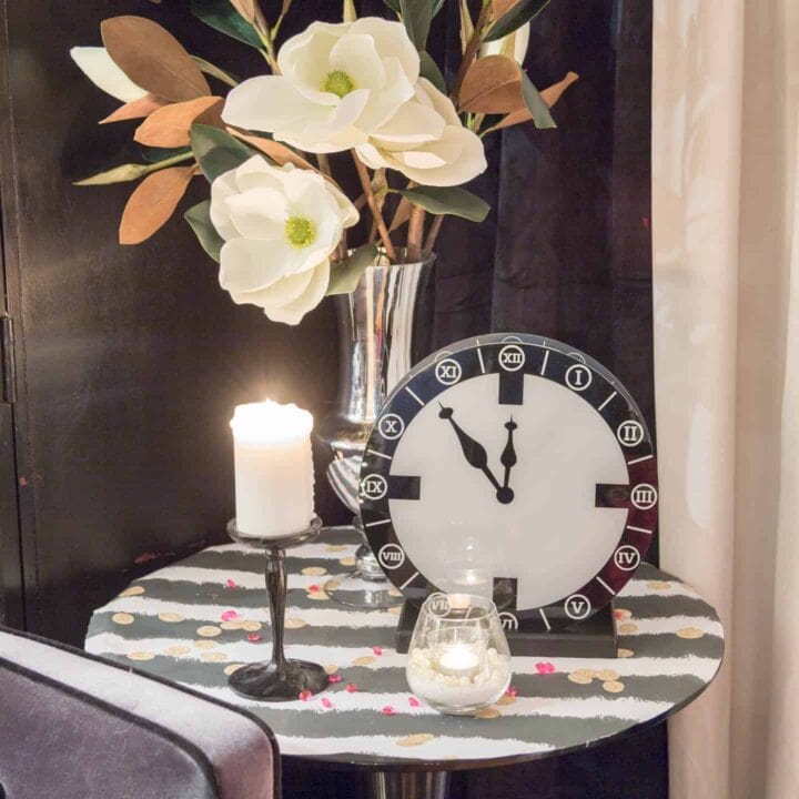 A clock, candles and flowers at a New Year's Eve party