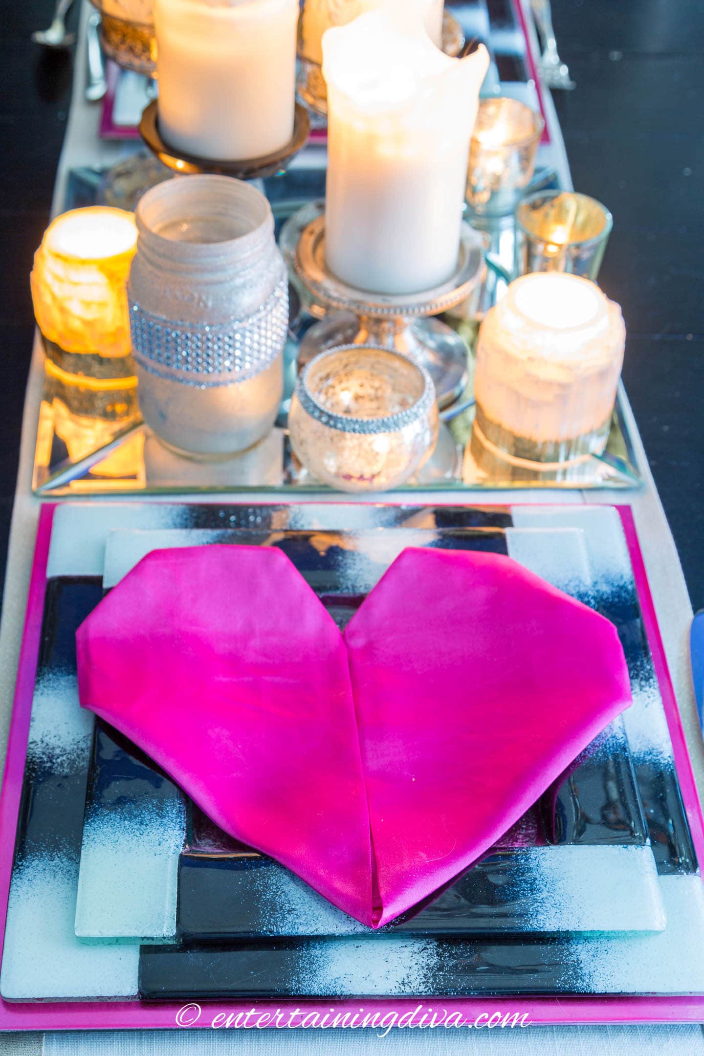 A napkin folded into a heart shape on a black and white Valentine table setting