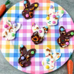 Bunny-shaped white and milk chocolate Easter bark on a colorful plate