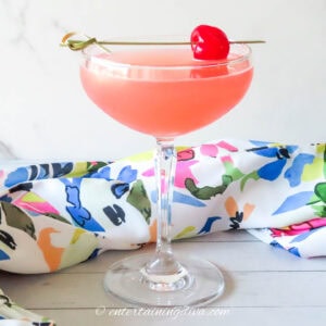 side view of a pink Master's Azalea cocktail in a coupe glass