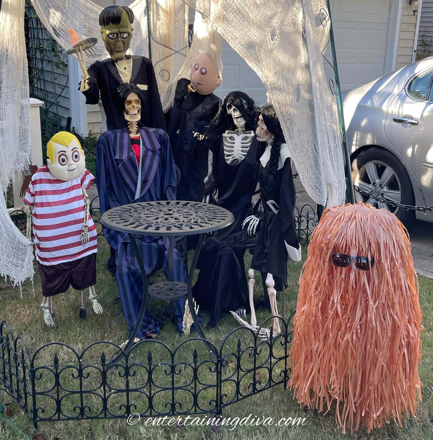 Skeletons dressed up like members of the Addams family - Pugsley, Thing, Gomez, Uncle Fester, Morticia, Wednesday and Cousin Itt