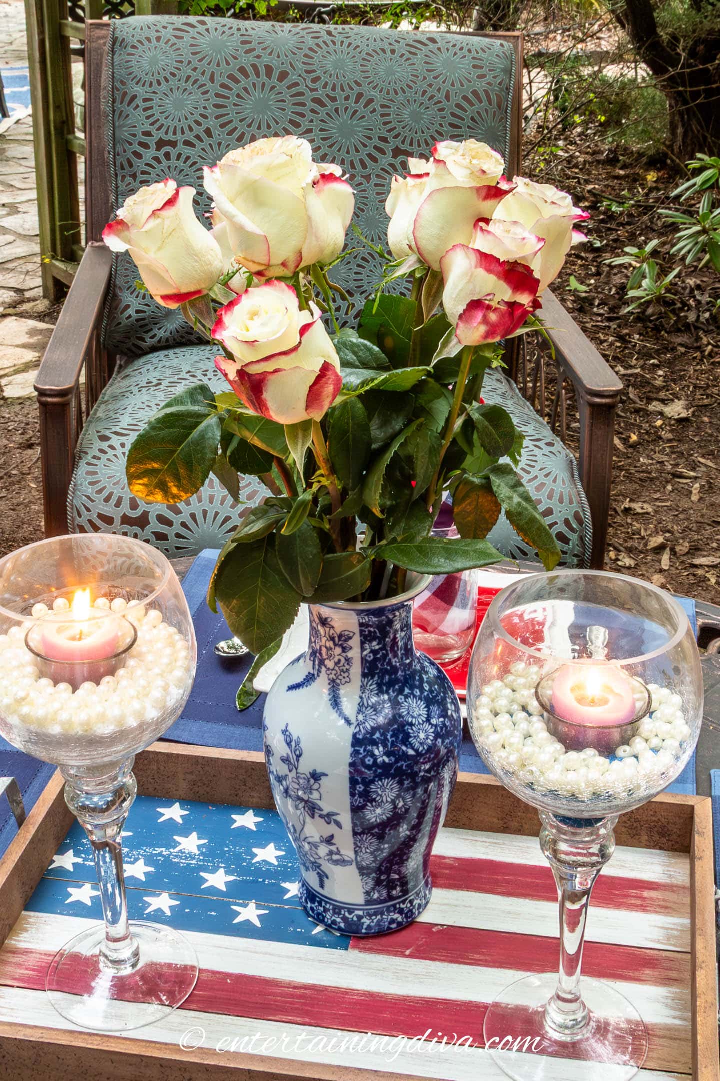 red and white roses in a blue and white vase on a 4th of July tablescape