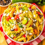 overhead view of a bowl of Greek pasta salad with feta cheese and olives