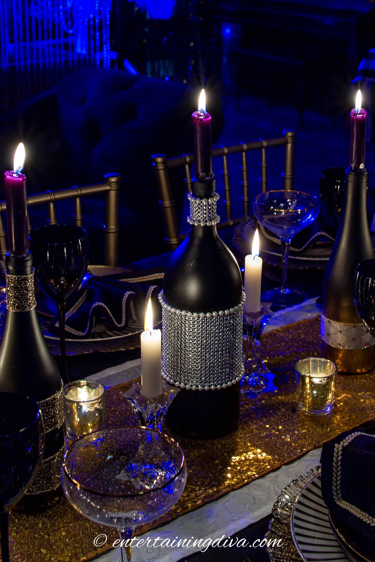 black wine bottle candleholder decorated with white pearls on a black white and gold tablescape