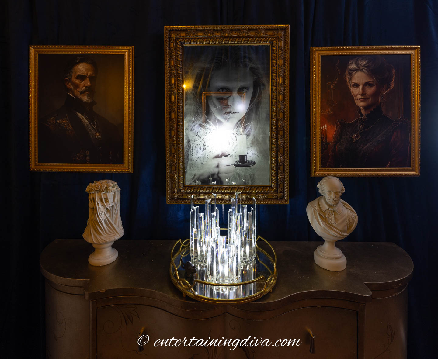 A haunted mirror between 2 spooky portraits over a console table