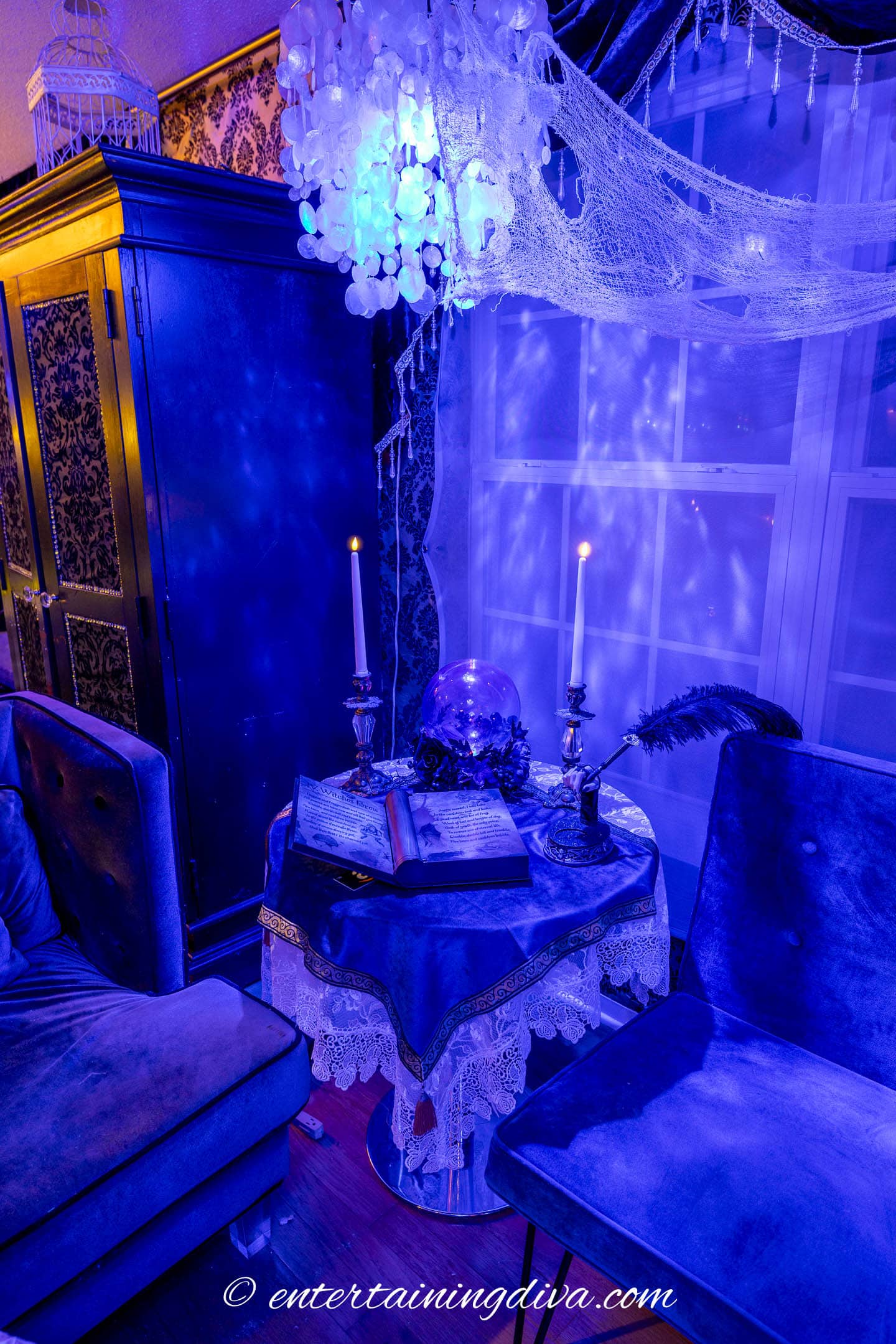 A seance table with an animated spell book, a crystal ball, a feather pen and candles in a haunted mansion Halloween party