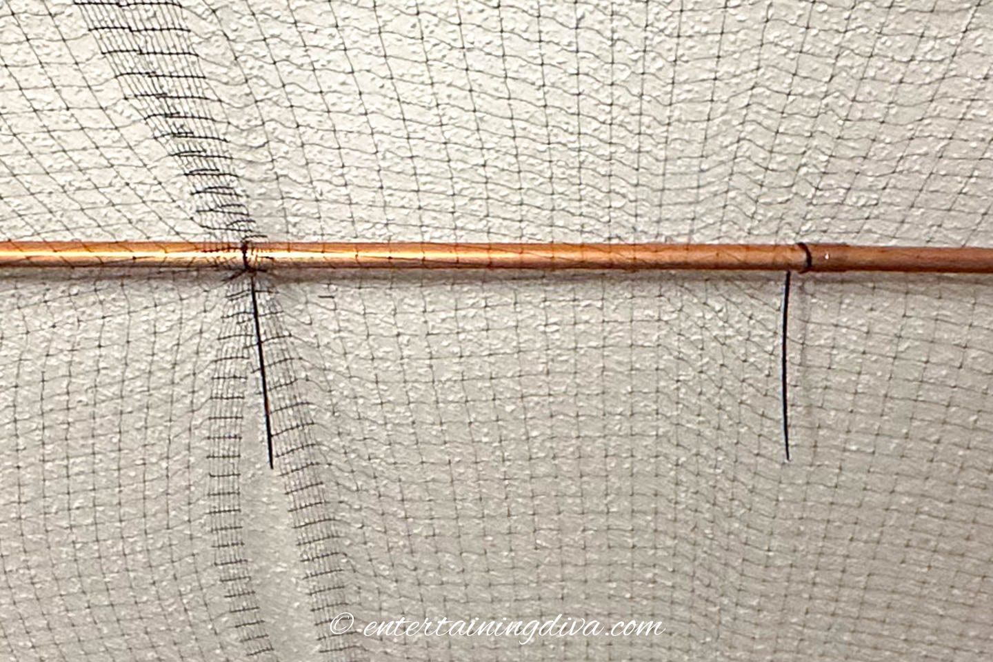 netting held on a curtain rod with zip ties