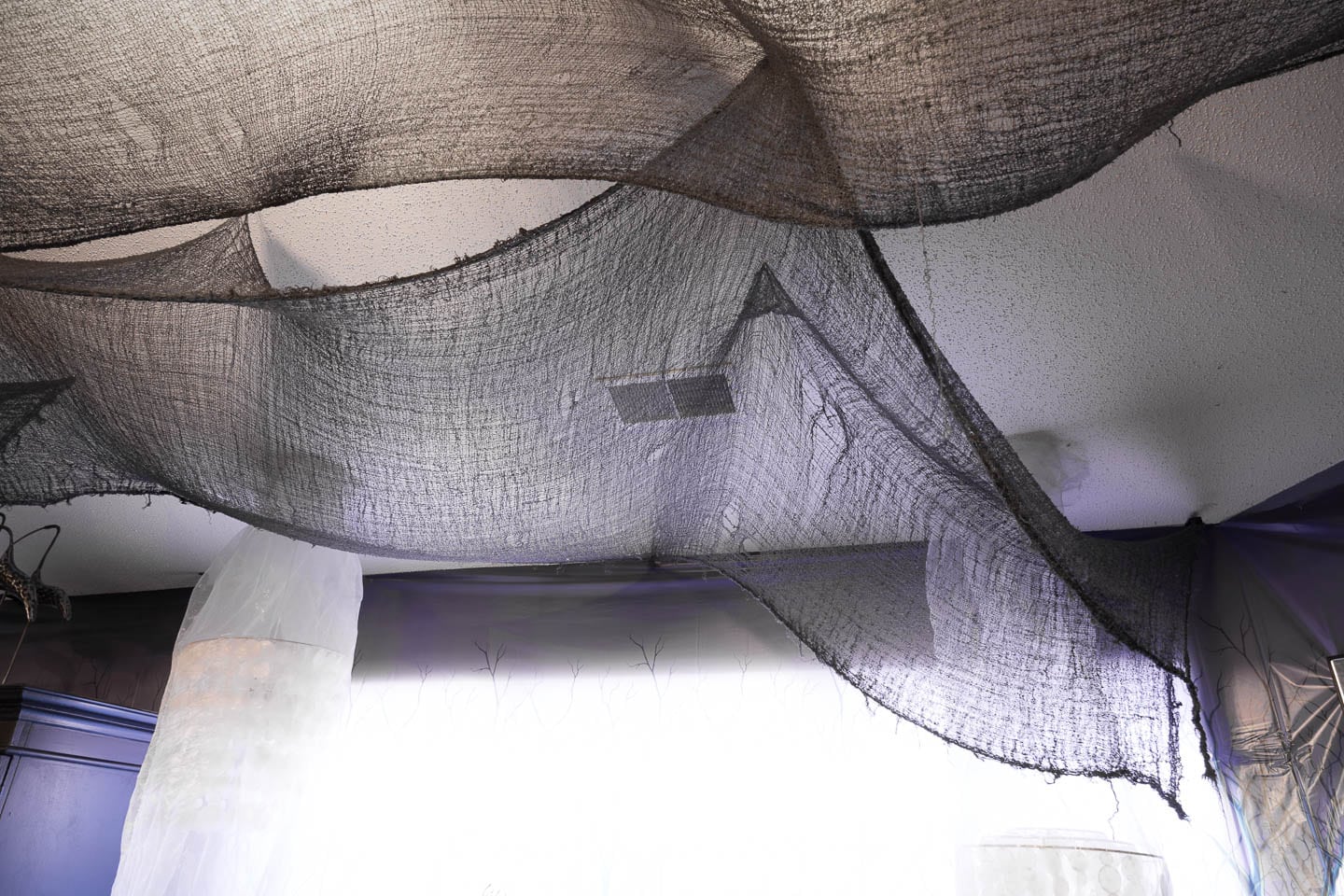Black creepy cloth hung from the ceiling with overlapping panels